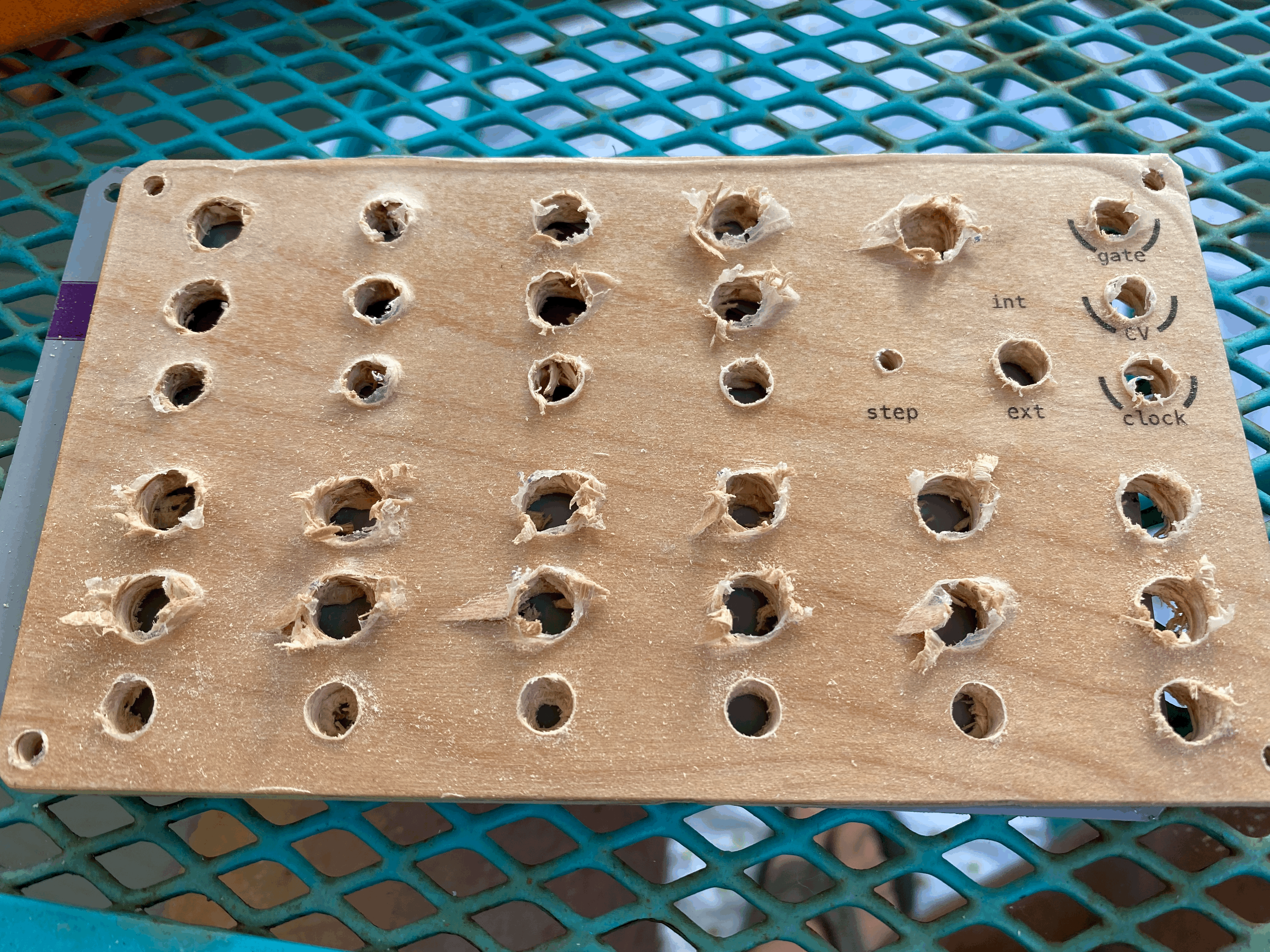 Wooden synthesizer panel with tears in component holes